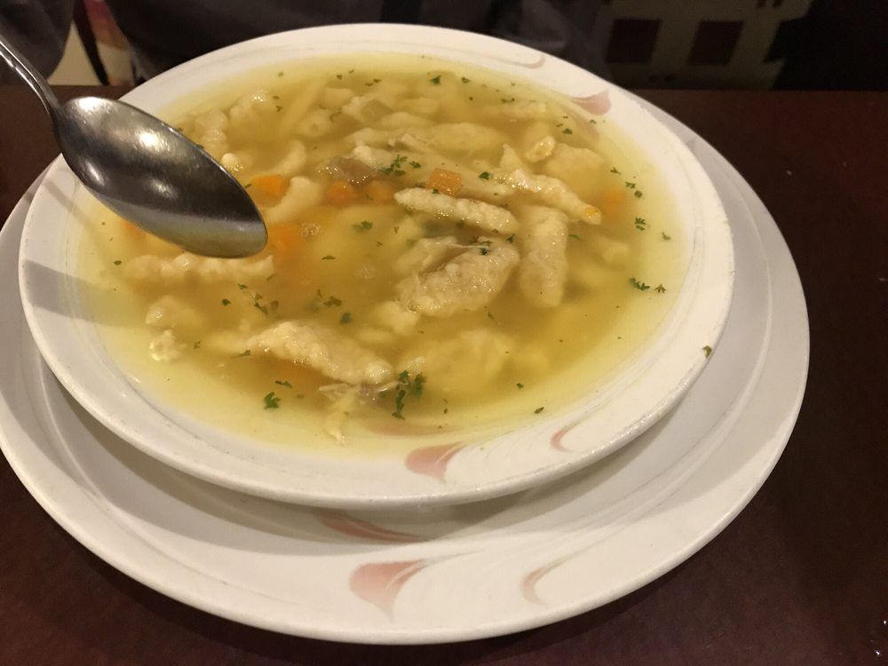 A bowl of chicken noodle soup with a spoon in it