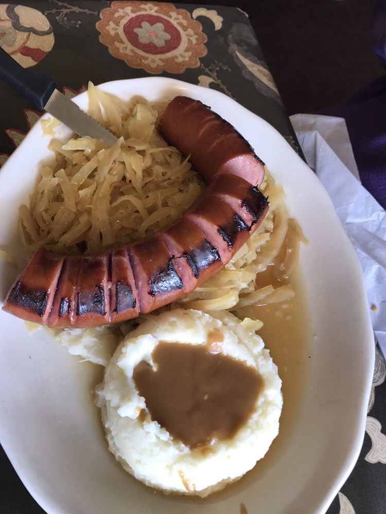 A plate of food with a sausage and mashed potatoes