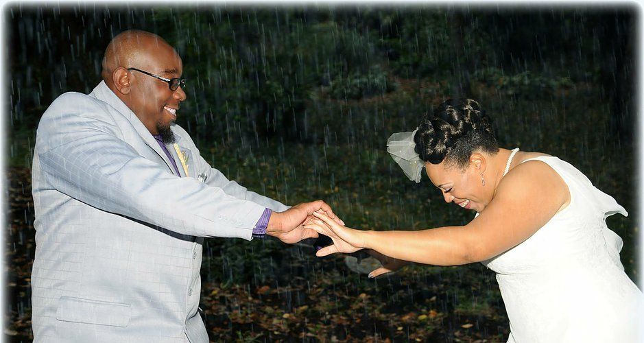 A man and a woman are holding hands in the rain