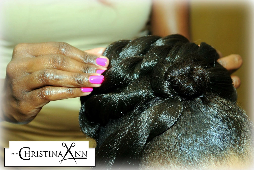 A woman 's hair is being styled by christina ann