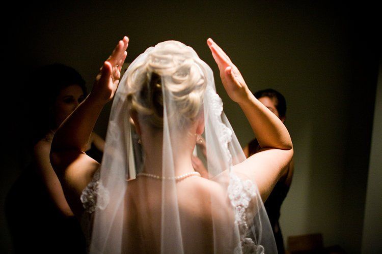 A bride wearing a veil is getting ready for her wedding