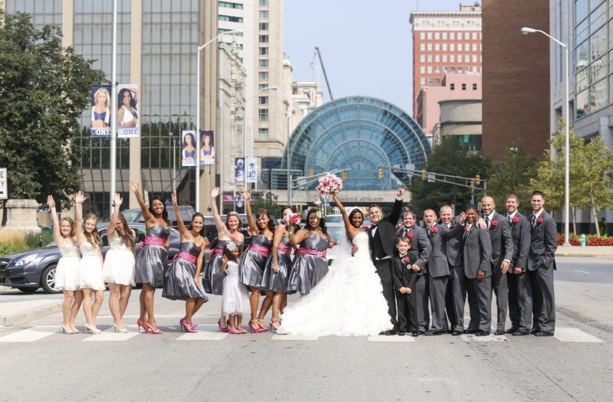The bride and groom are posing for a picture with their wedding party
