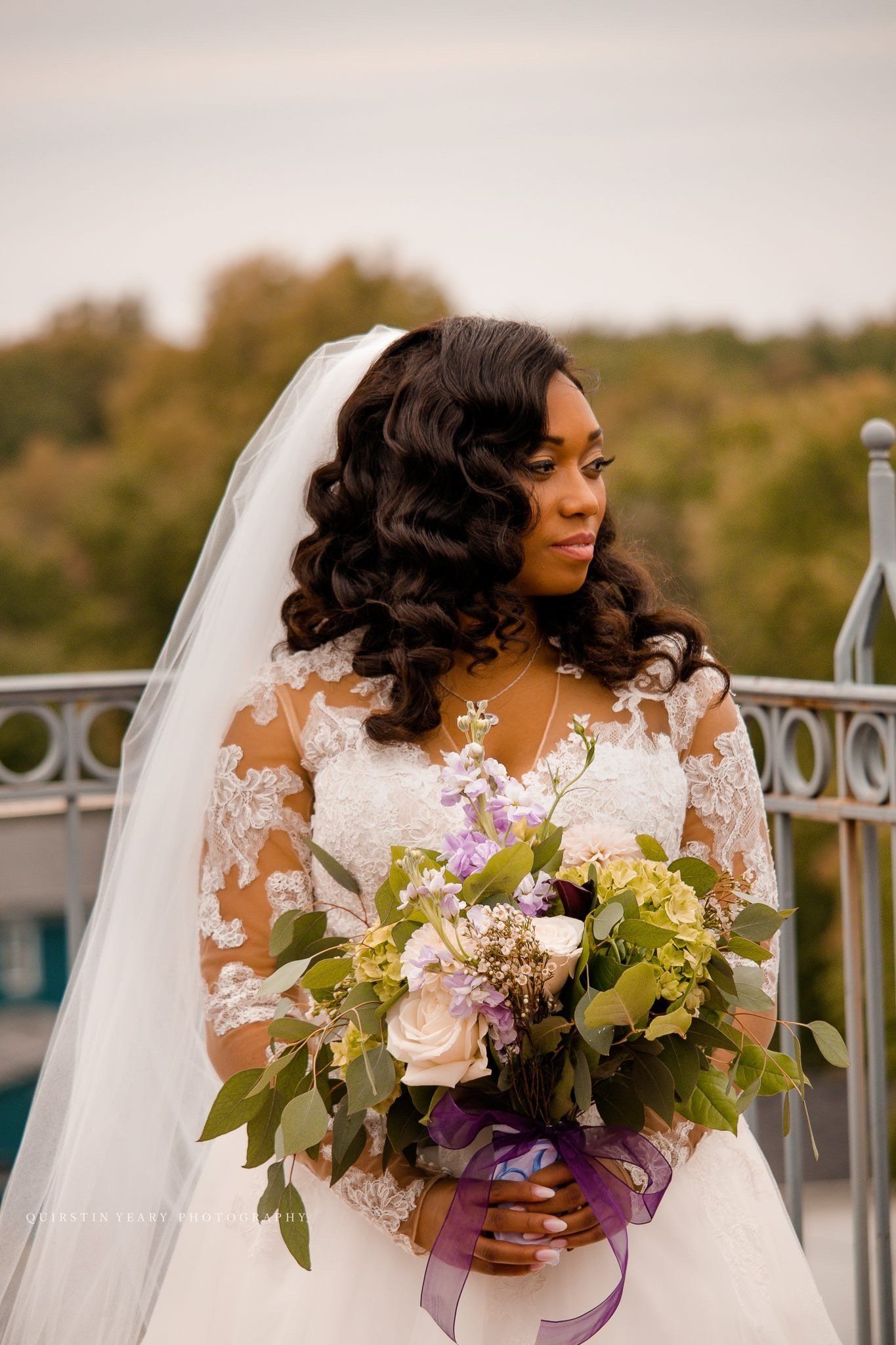 A bride in a wedding dress is holding a bouquet of flowers.