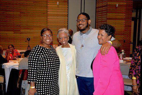 Four people at an event pose together