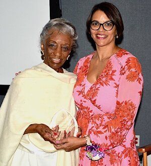 Two women, one older and one younger, smiling and holding a trophy