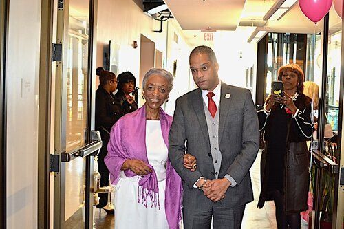 A woman and a man walk down a hallway