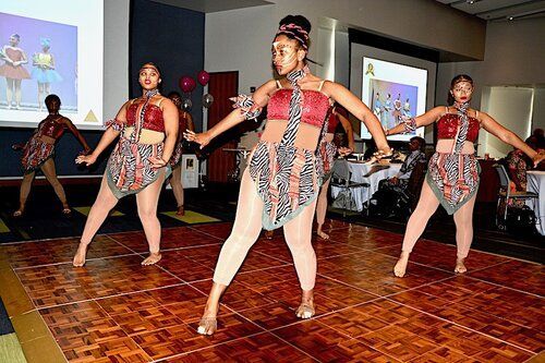 Dancers performing on a wood floor stage