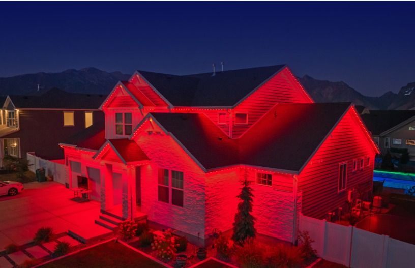 House exterior illuminated with red lights at night.