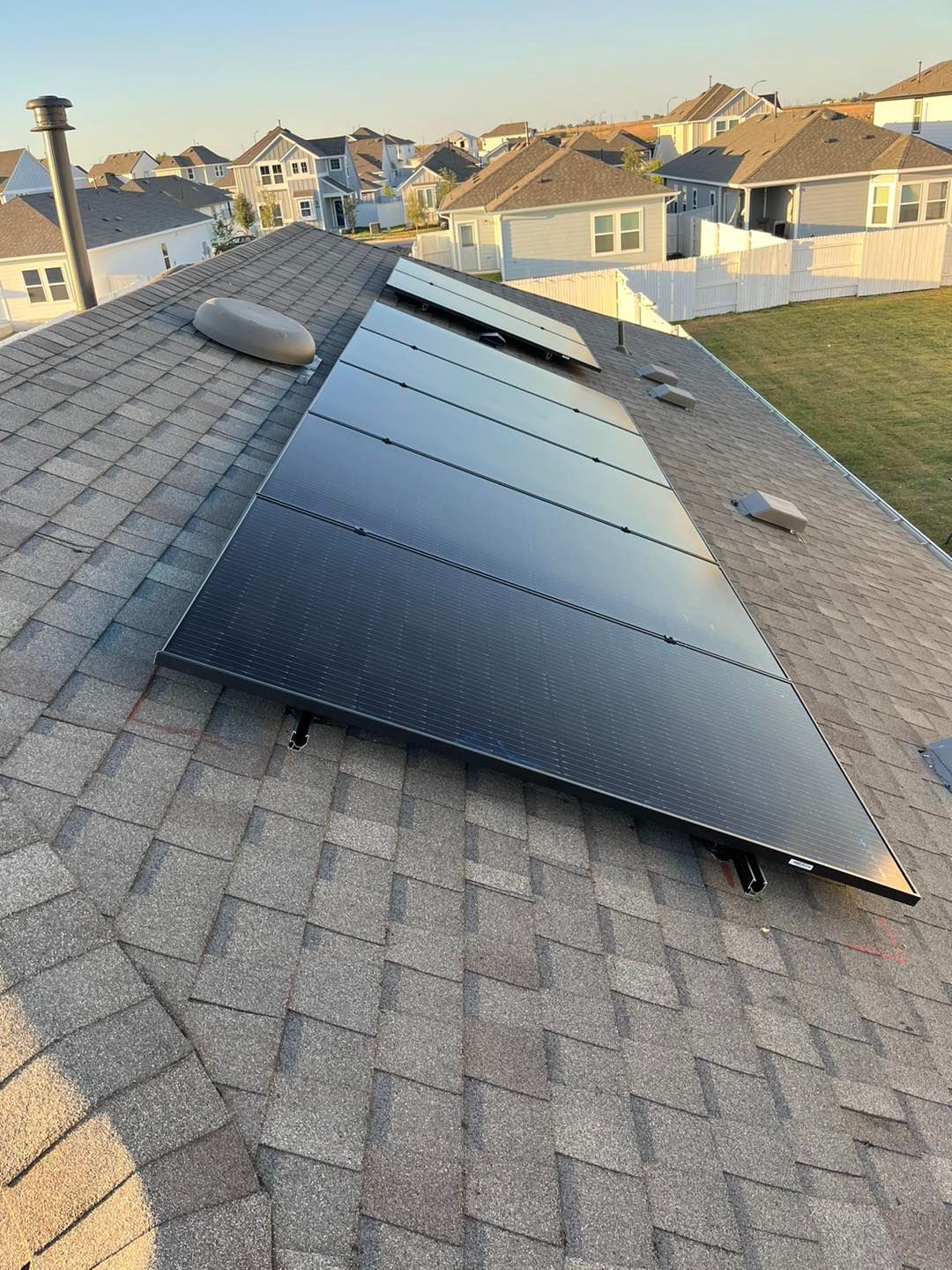 Solar panels installed on a residential rooftop. Panels are dark against a gre
