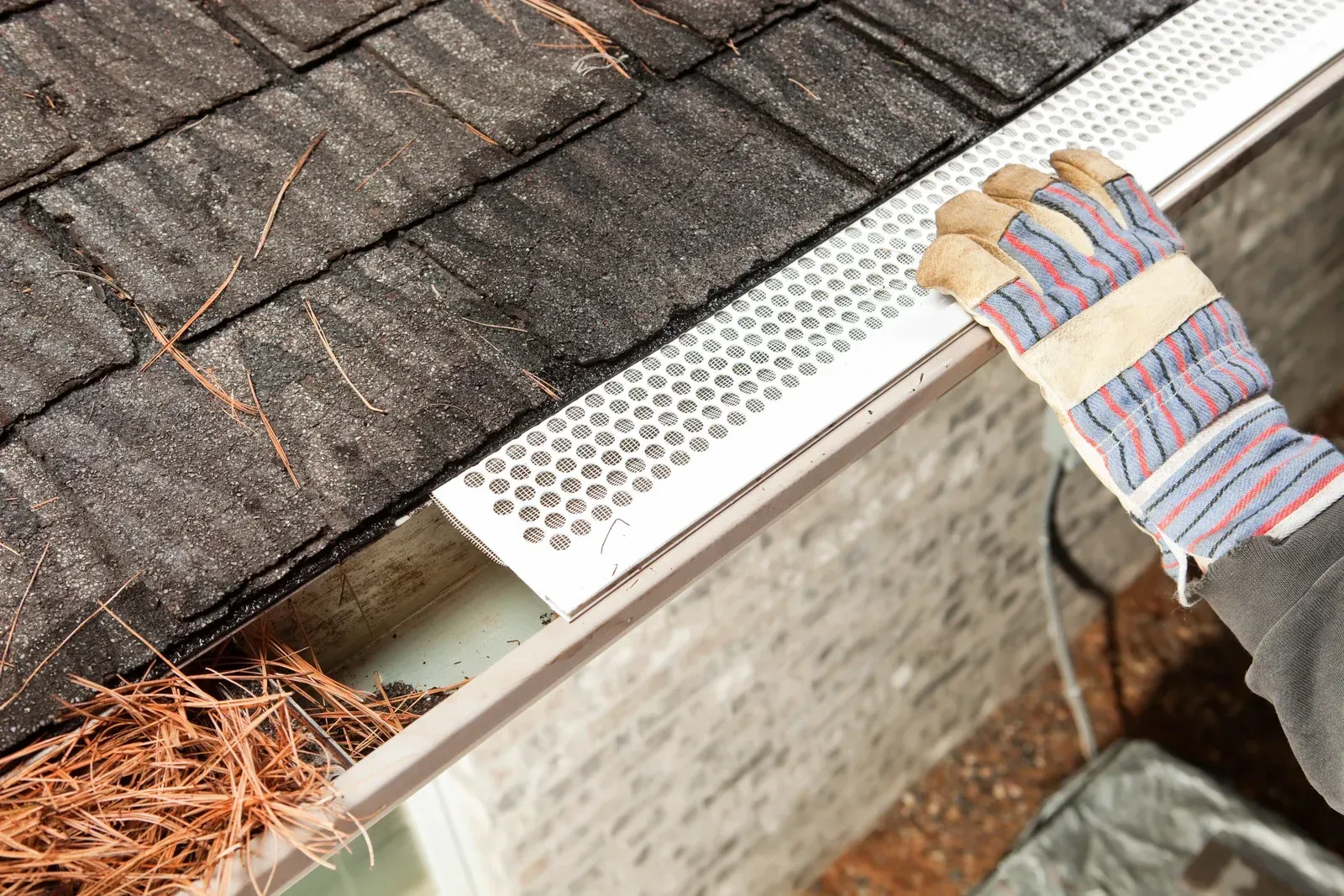 Gutter guard installed on roof. Gutter is filled with mesh to catch debris.