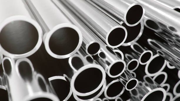 Galvanised Pipe stacks in industrial setting, shiny steel tubes for manufacturing background.