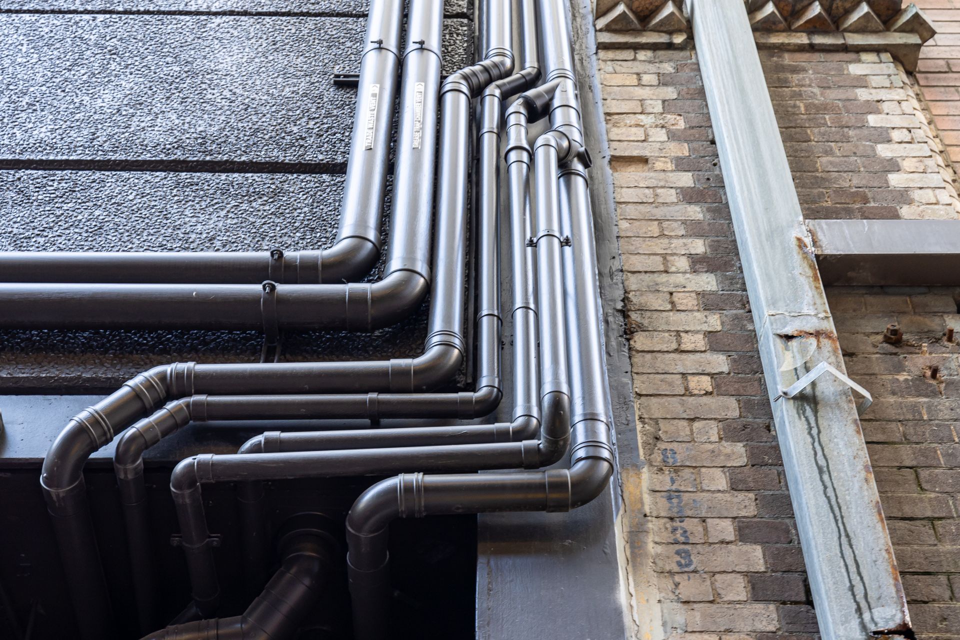 Galvanised pipe on the side of a building. 