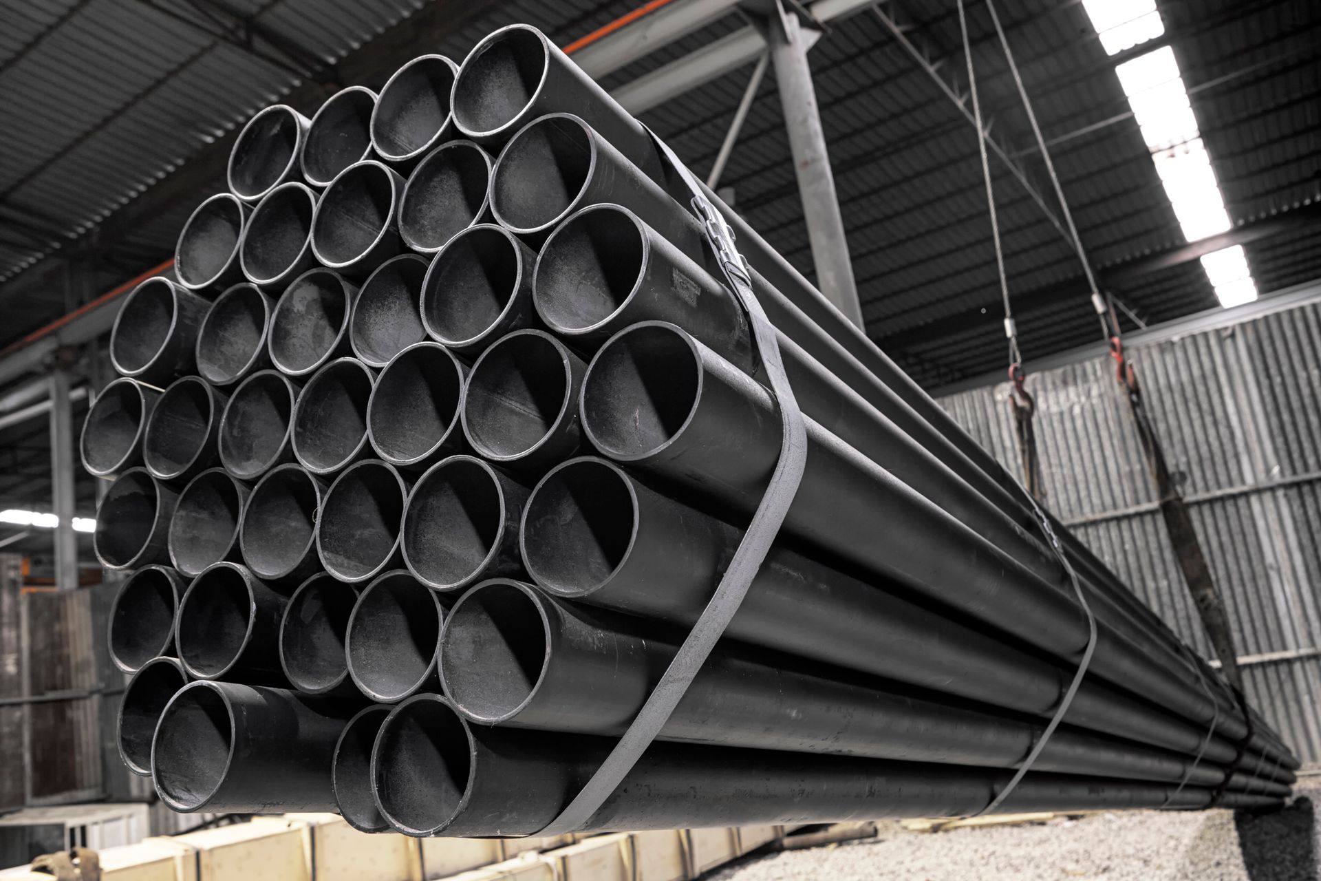 A pile of galvanised pipe being moved for shipping.