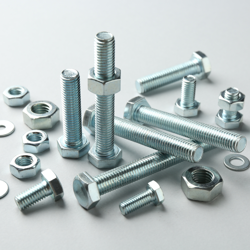 Assorted silver bolts, screws, nuts, and washers arranged on a light gray surface