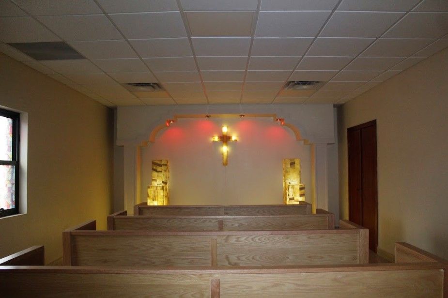 Una iglesia vacía con una cruz en la pared