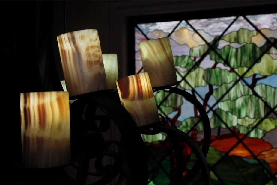 Una vidriera con velas delante.