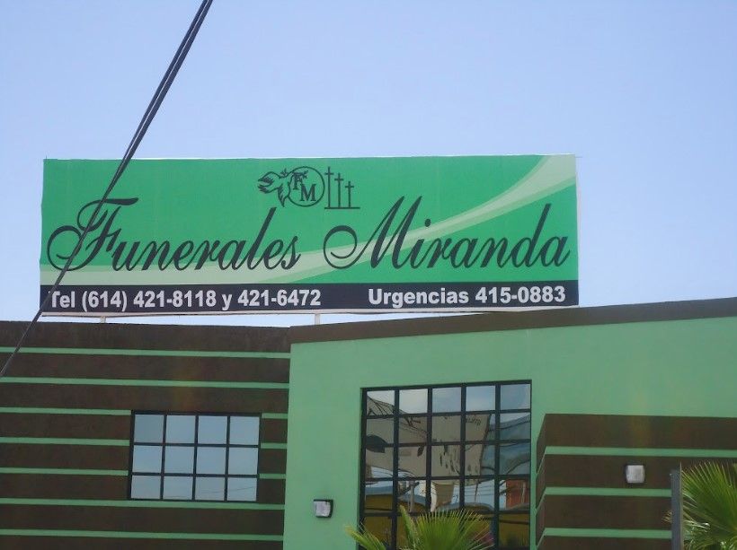 Un edificio verde con un cartel que dice Funerales Miranda.