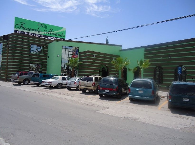 Una fila de autos están estacionados frente a un edificio verde que dice funerale mirada