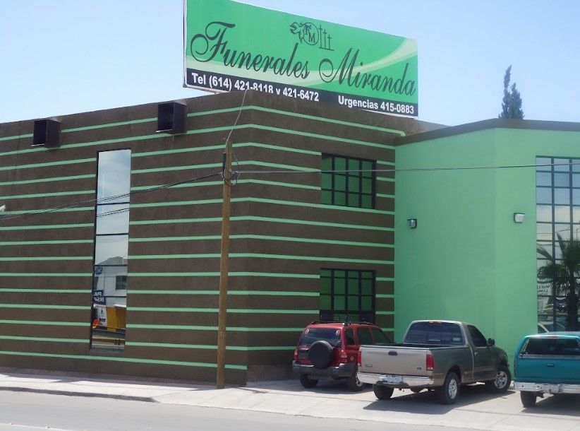 Un edificio verde con un cartel que dice Funerales Miranda.