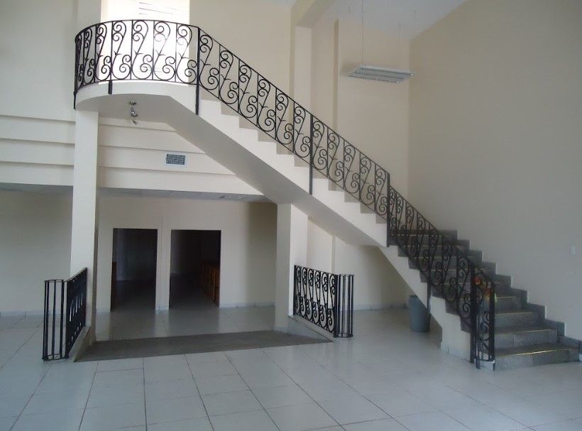 Una escalera con barandilla de hierro forjado en una habitación vacía.