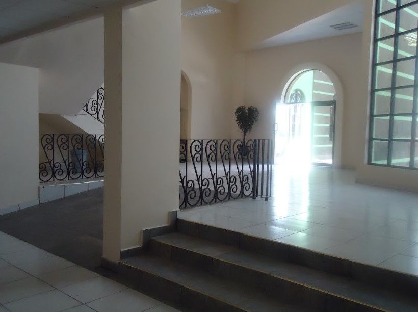 Una habitación vacía con escaleras y una valla que dice 'sss'.