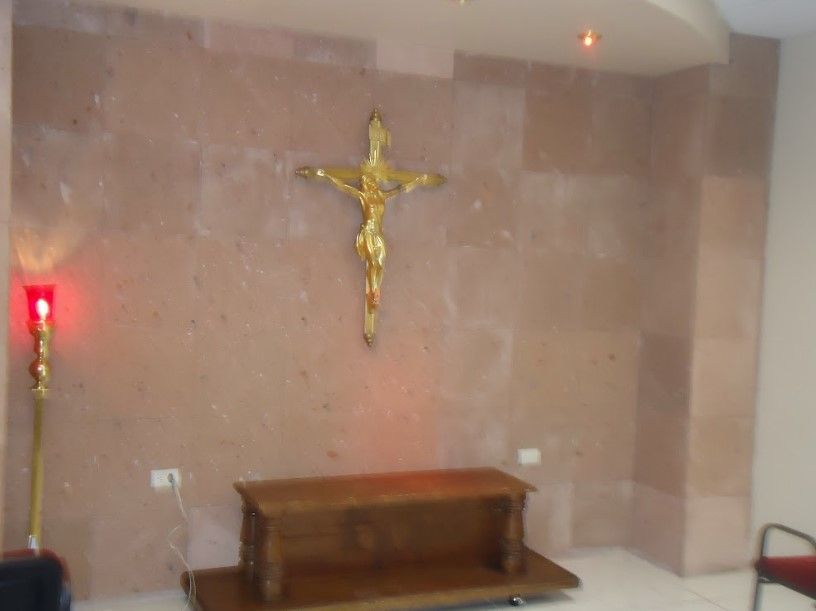 Una pequeña habitación con una cruz en la pared.