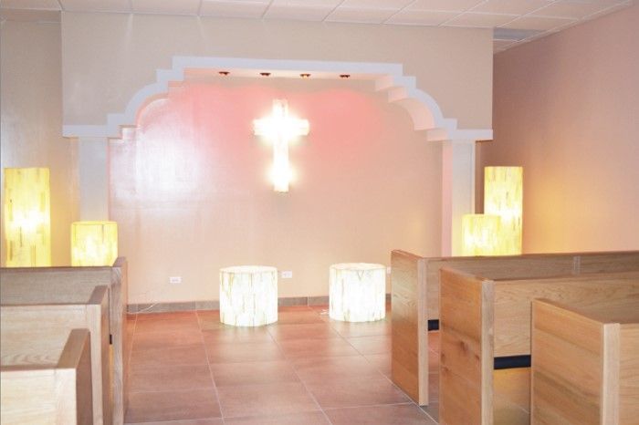 Una iglesia con una cruz en la pared y velas