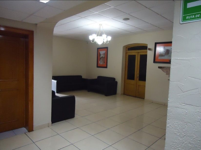 Una habitación con una señal de salida verde en la pared
