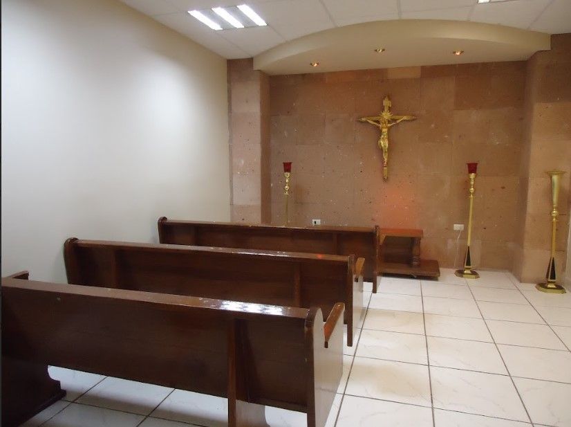 Una iglesia vacía con una cruz en la pared