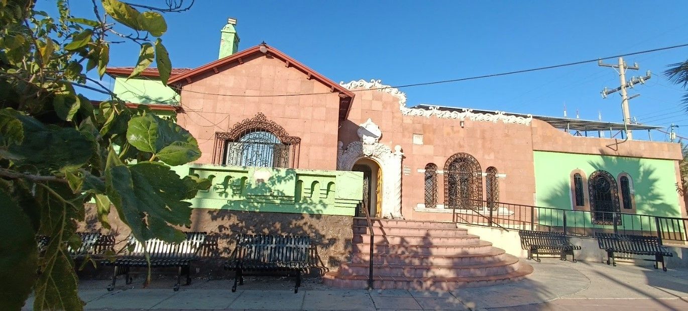 Un gran edificio de ladrillo con molduras y escaleras verdes.