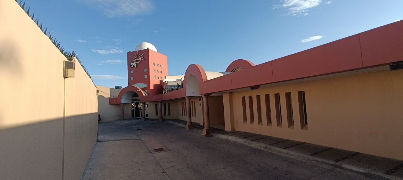 Un callejón estrecho que conduce a un edificio con techo rojo.