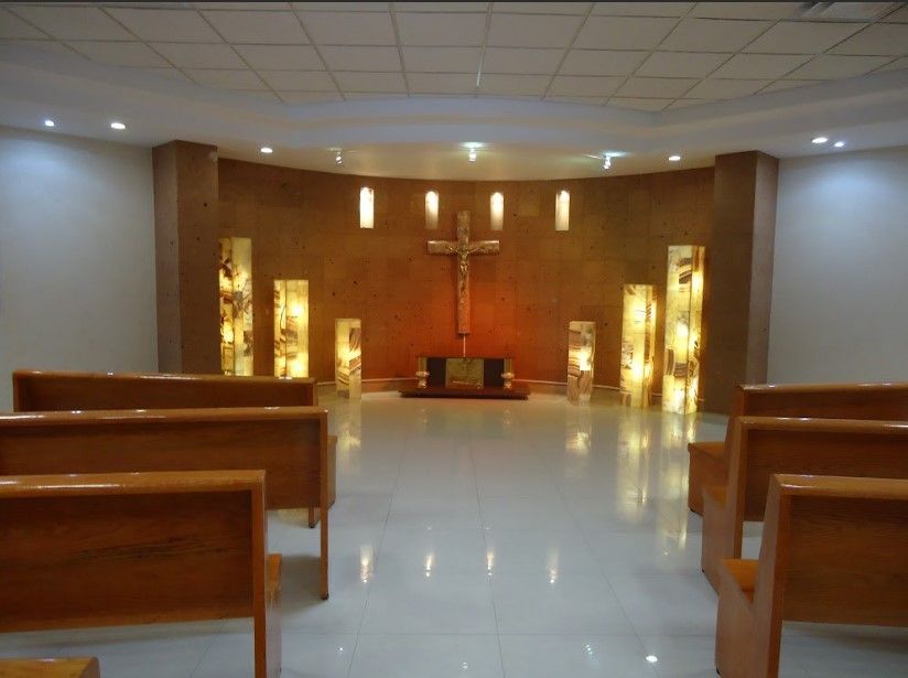 Una iglesia con bancos de madera y una cruz en el medio