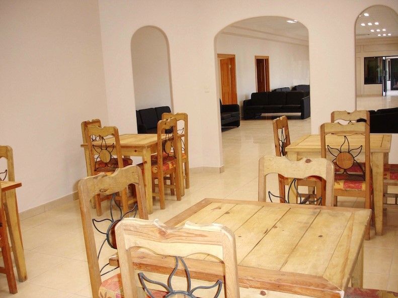 Una habitación con mesas y sillas de madera.