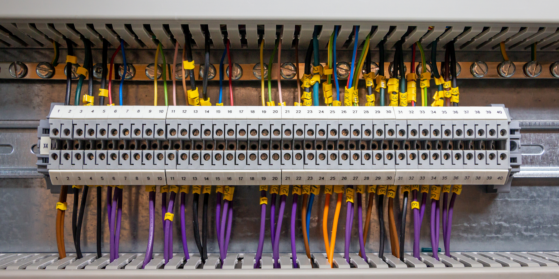 Electrical panel with rows of colored wires connected to terminals.
