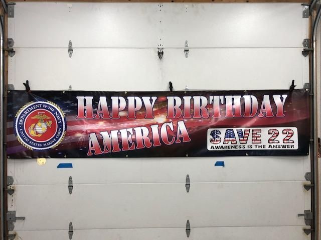 A happy birthday america banner hangs on a garage door