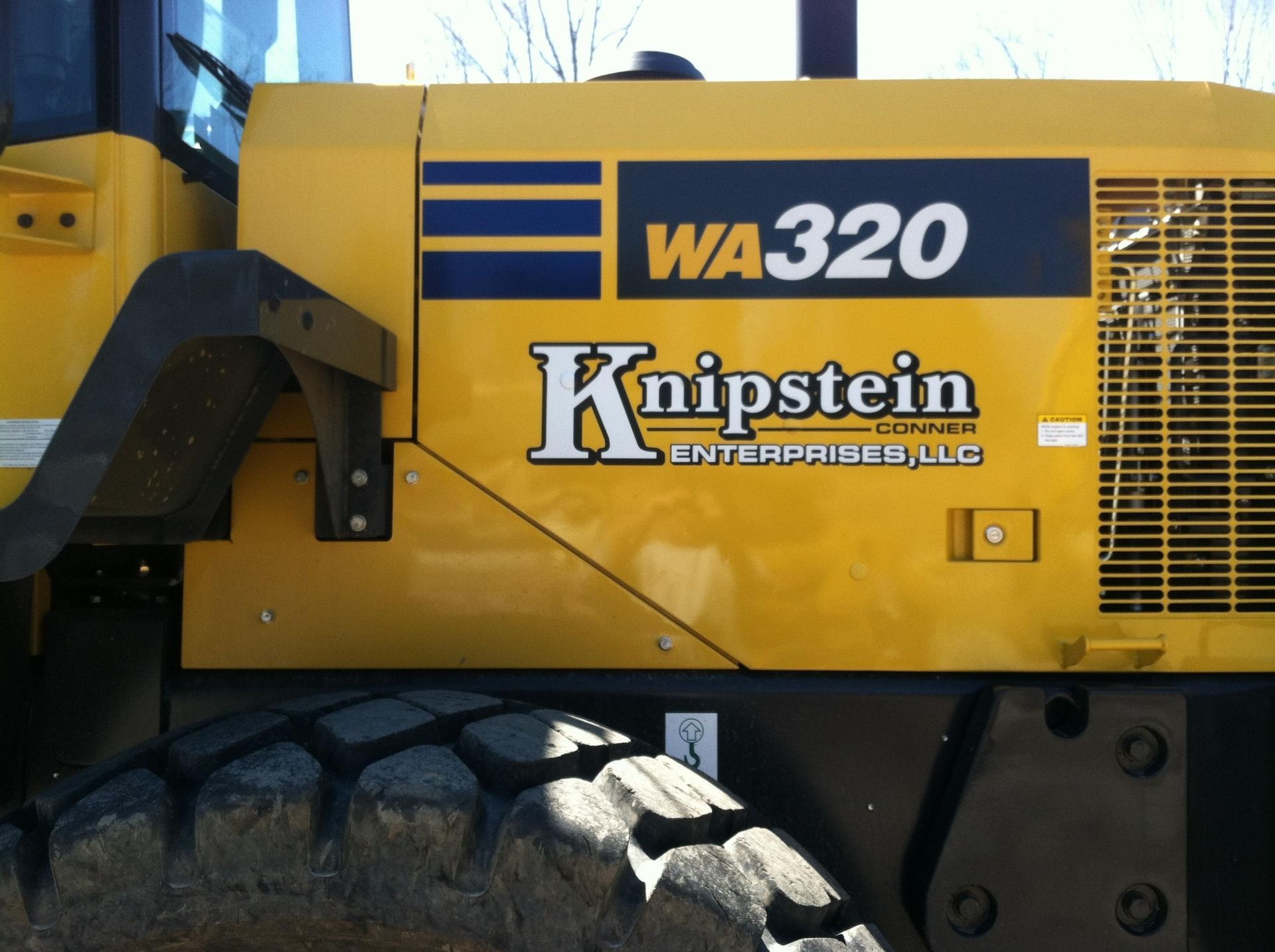A knipstein enterprise llc logo on a yellow vehicle