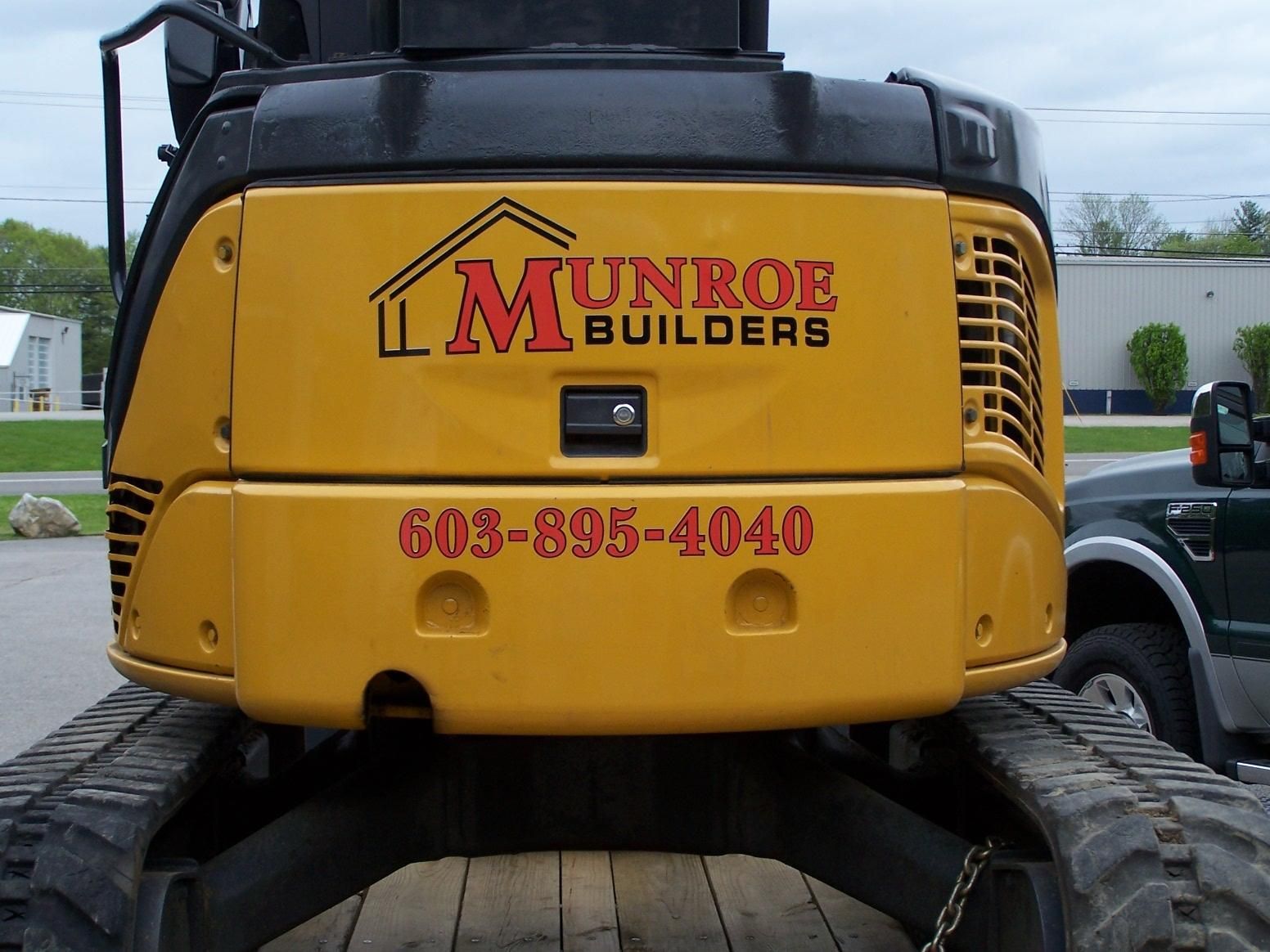 A yellow truck with munrob builders written on the back