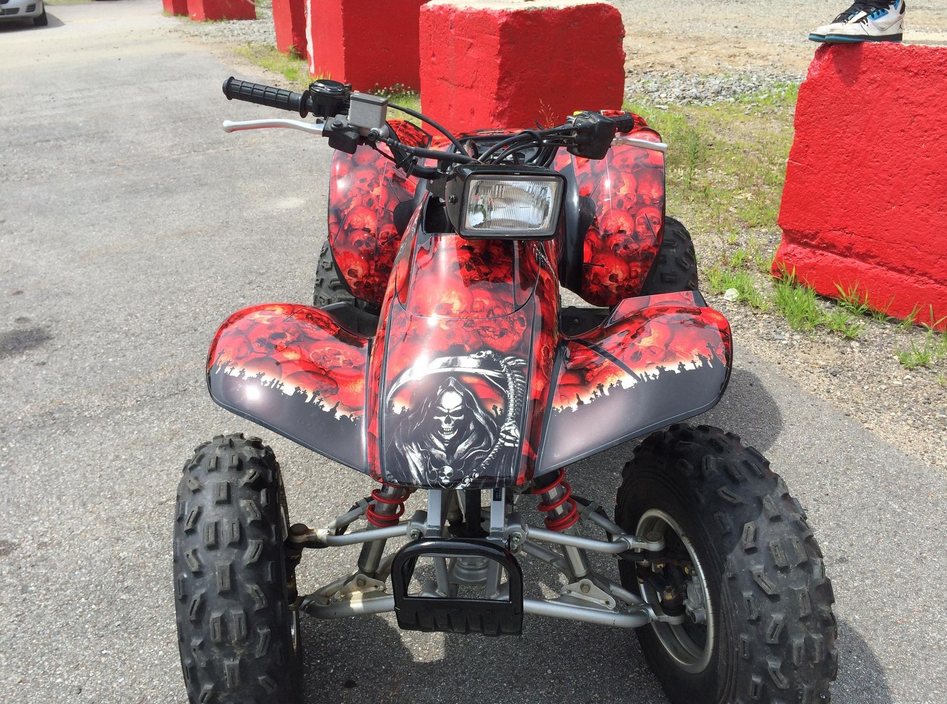 A red and black atv is parked in a parking lot