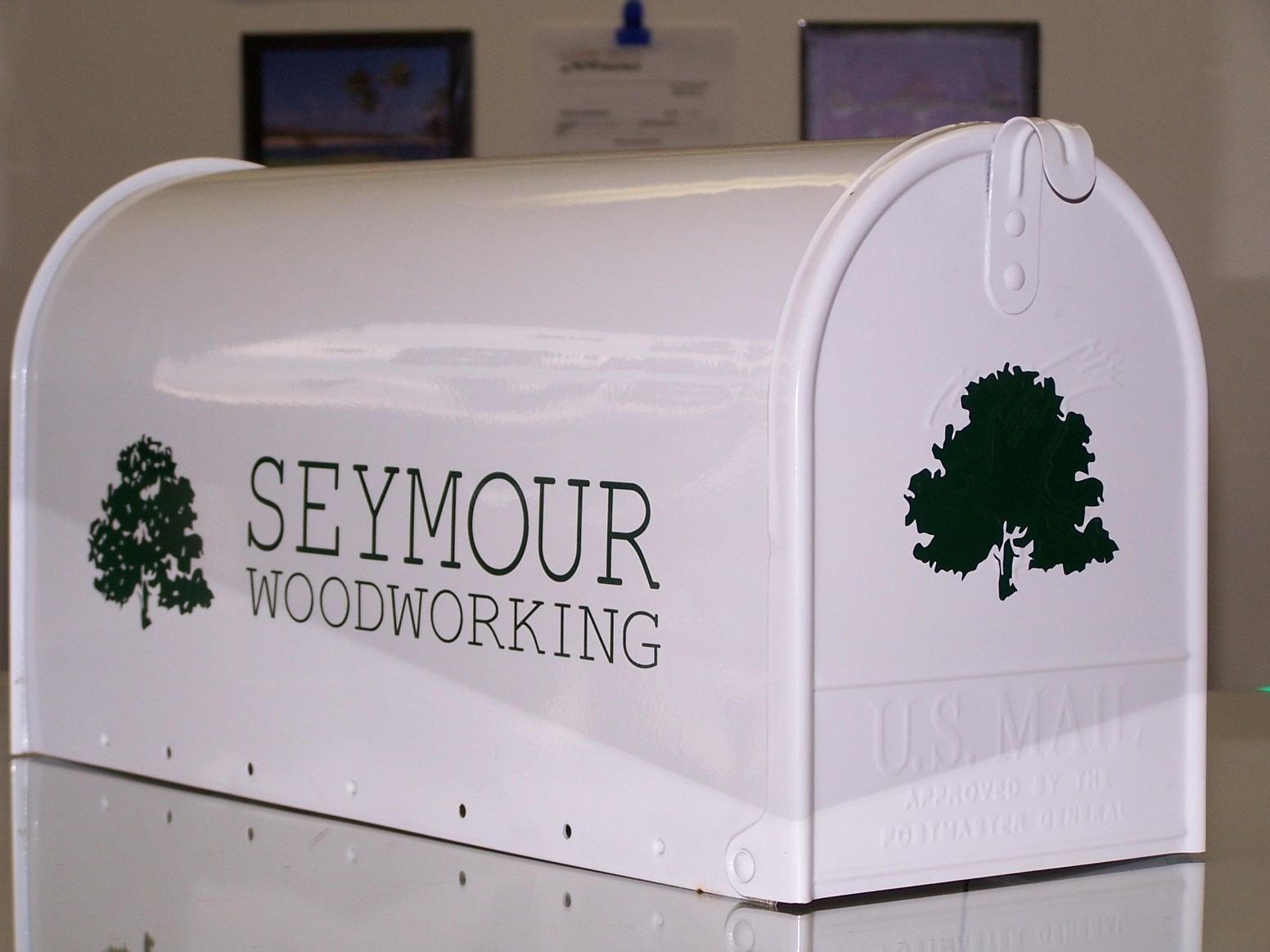 A white mailbox that says seymour woodworking on it