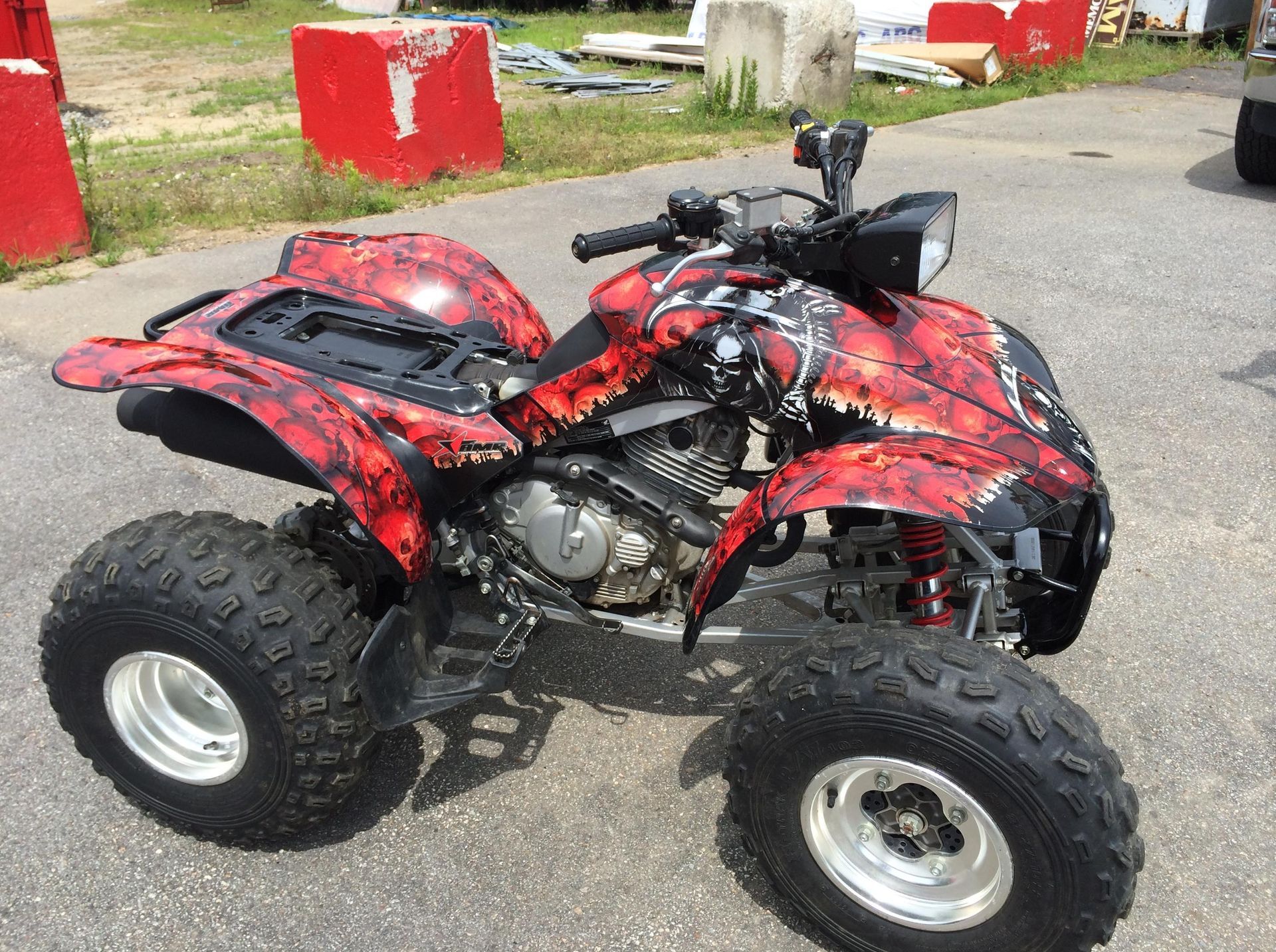 A red and black atv is parked on the side of the road