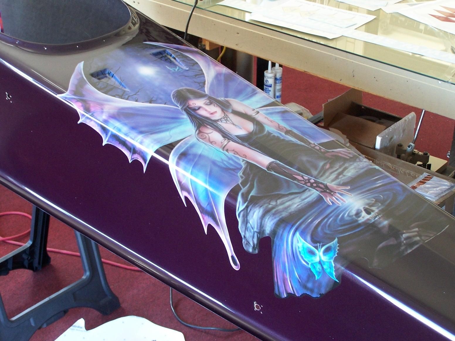 A purple coffin with a picture of a fairy on it