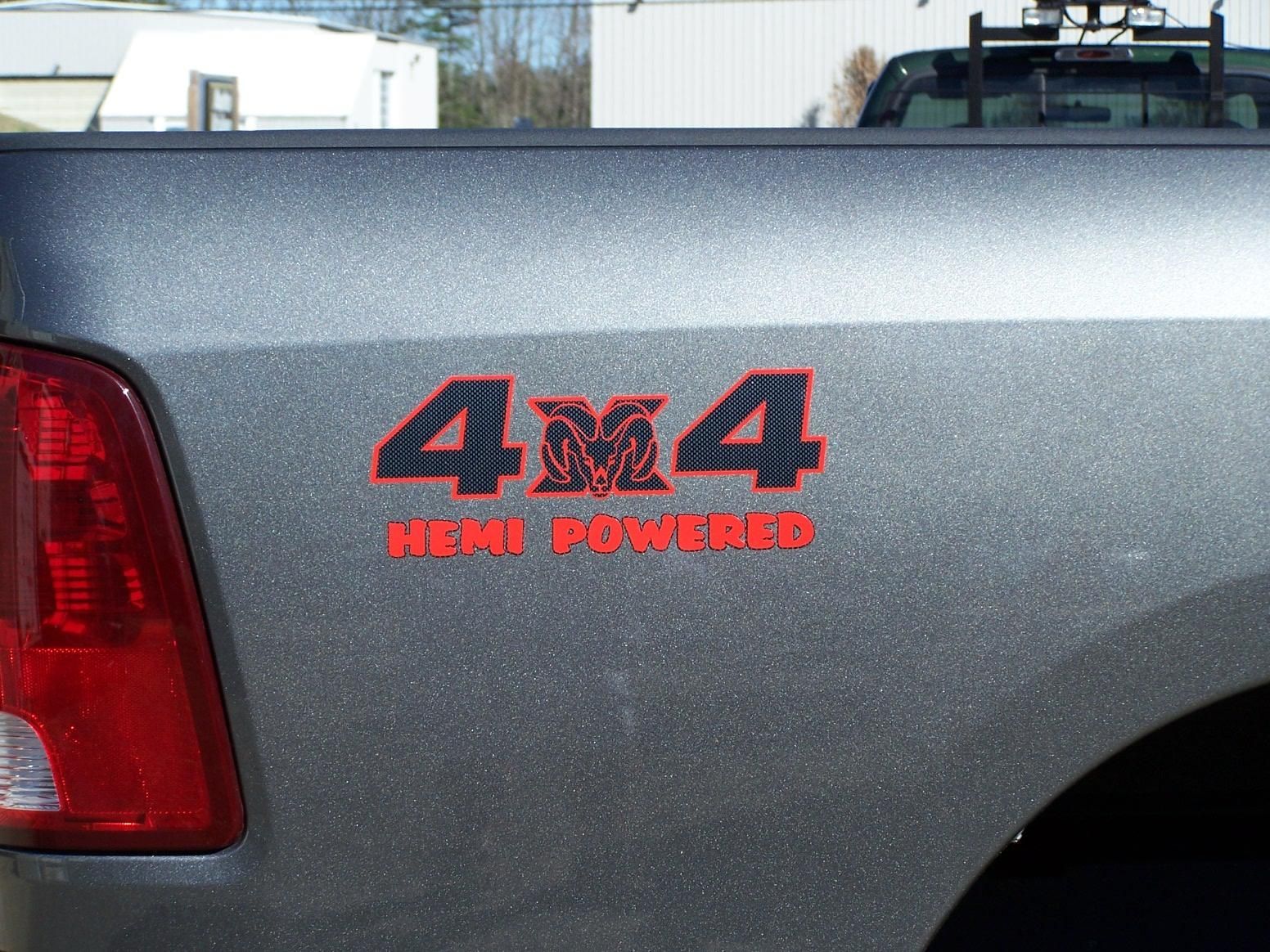 A gray truck with a red sticker on the back that says 4x4