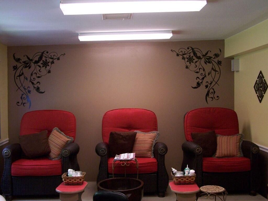 A room with three red chairs and a foot tub