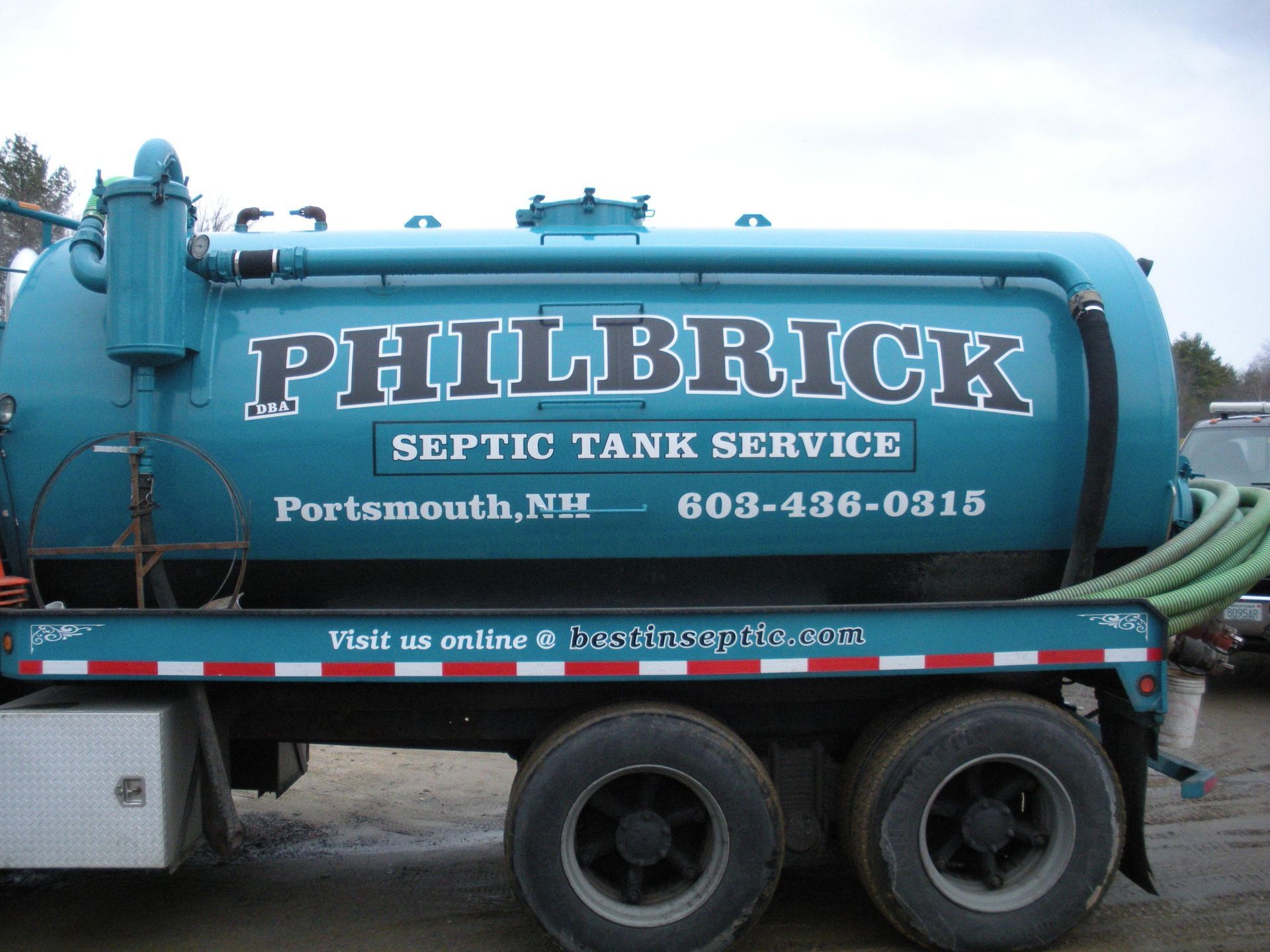 A philbrick septic tank service truck is parked in a parking lot