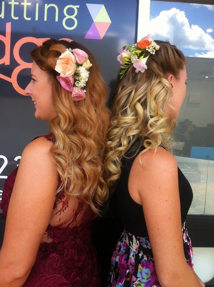 Two Women Standing Back to Back With Flowers in Their Hair — Coolum Cutting Edge in Peregian Springs, QLD