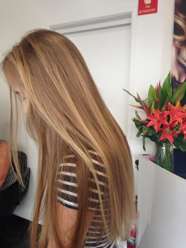 A Woman With Long Blonde Hair is Wearing a Striped Shirt — Coolum Cutting Edge in Peregian, QLD