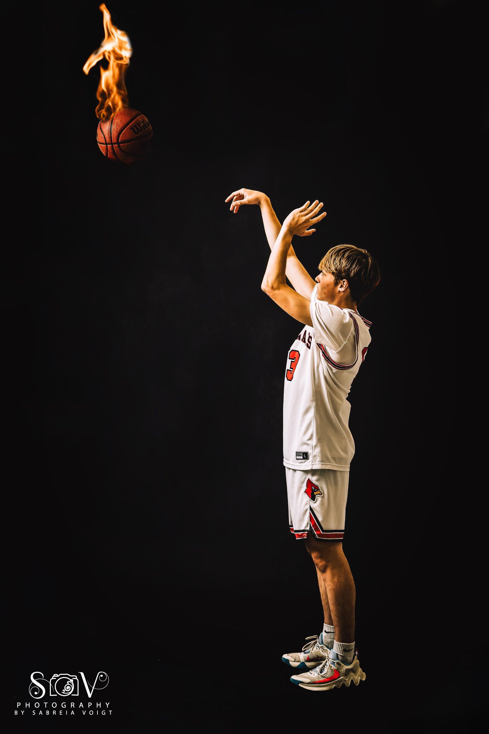 Basketball player shooting a flaming ball against a black background.