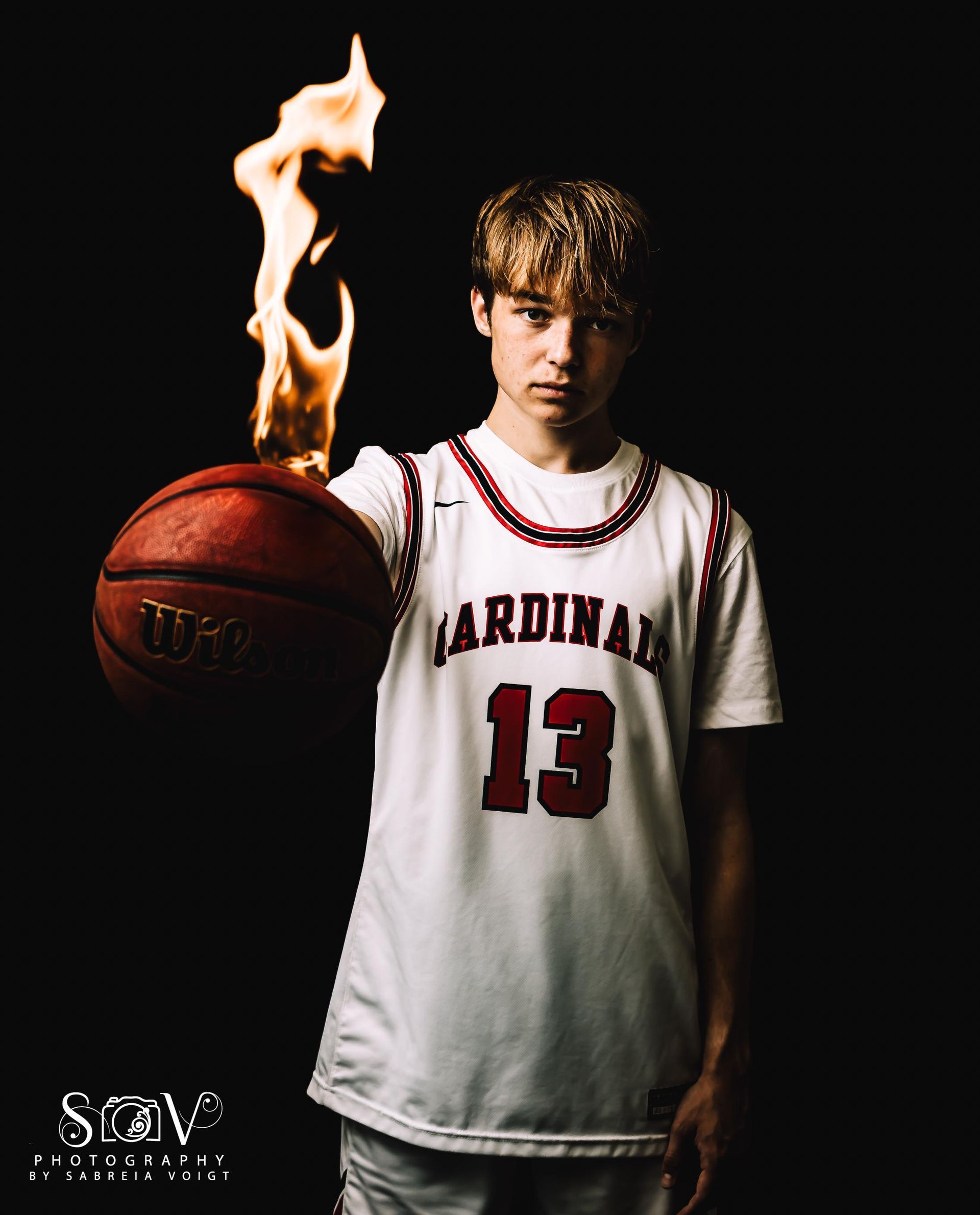 Basketball player holding a flaming ball, wearing a red and white 