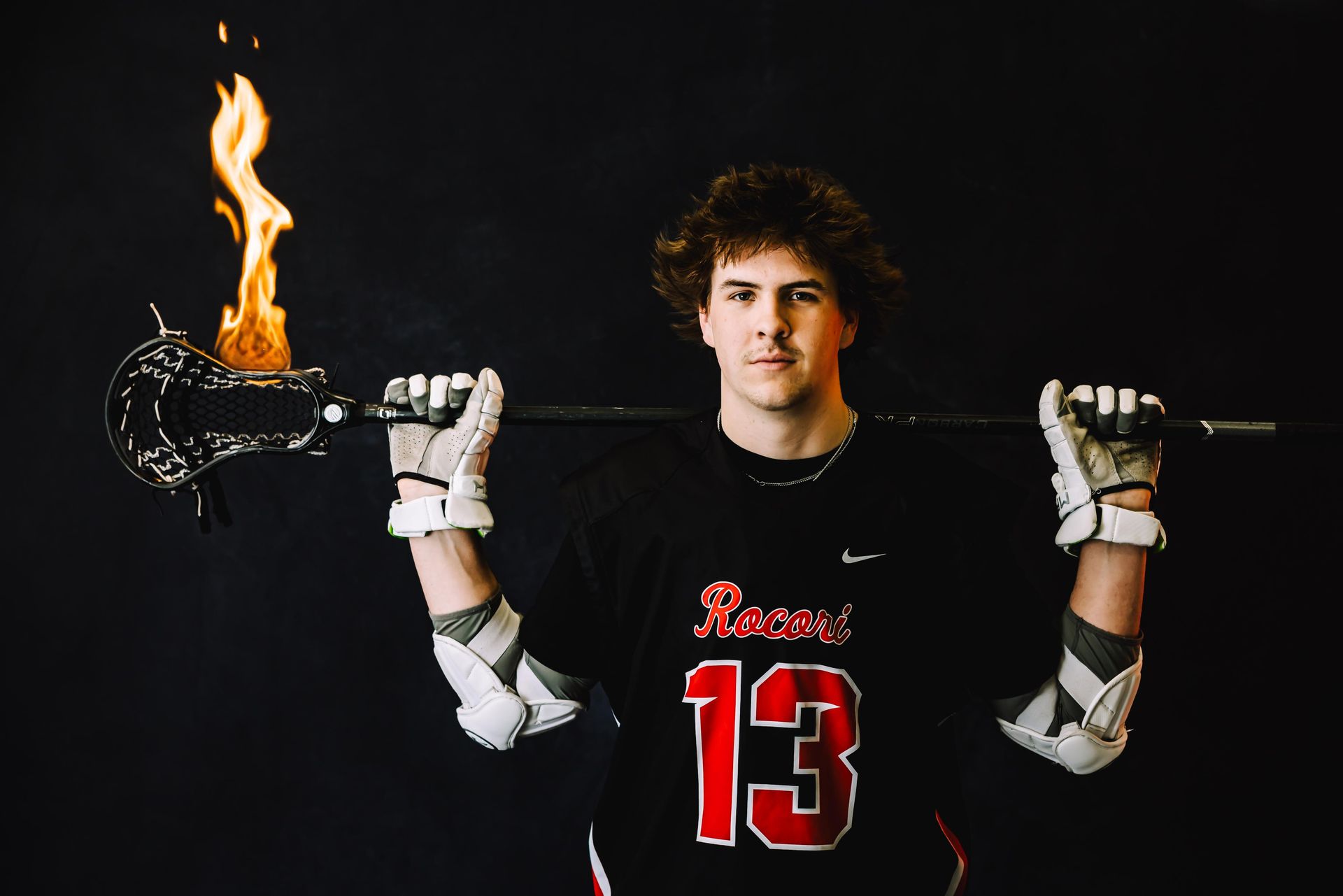 Lacrosse player with flaming stick, black shirt with 