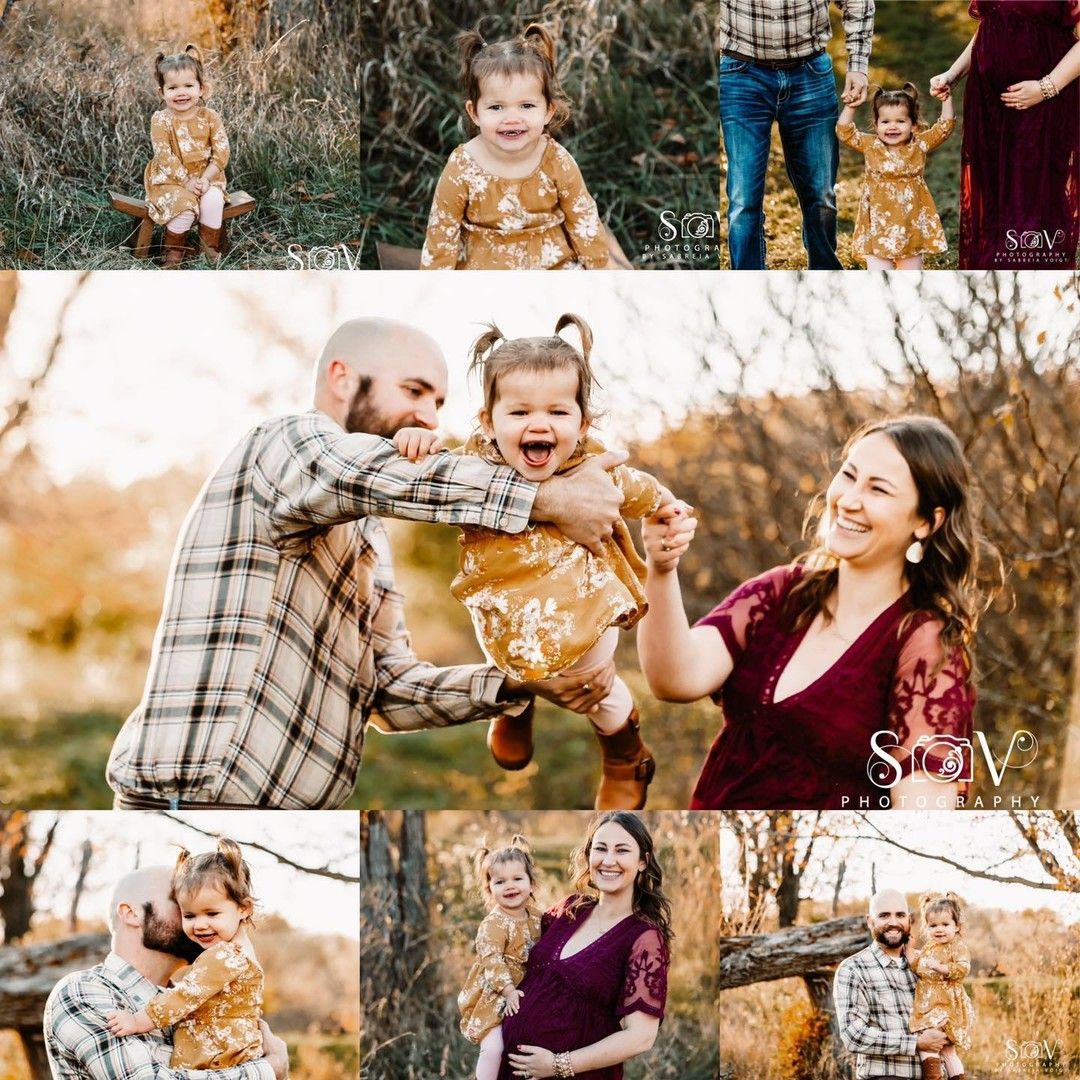 Family in autumn setting; father holding toddler girl, mother smiling. Girl in mustard dress, everyone happy.